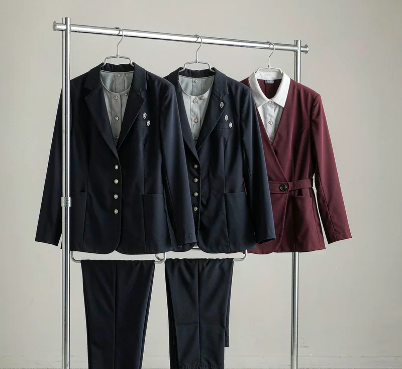 衣架上的女士工作服样衣:藏青外套配同色西裤与酒红款